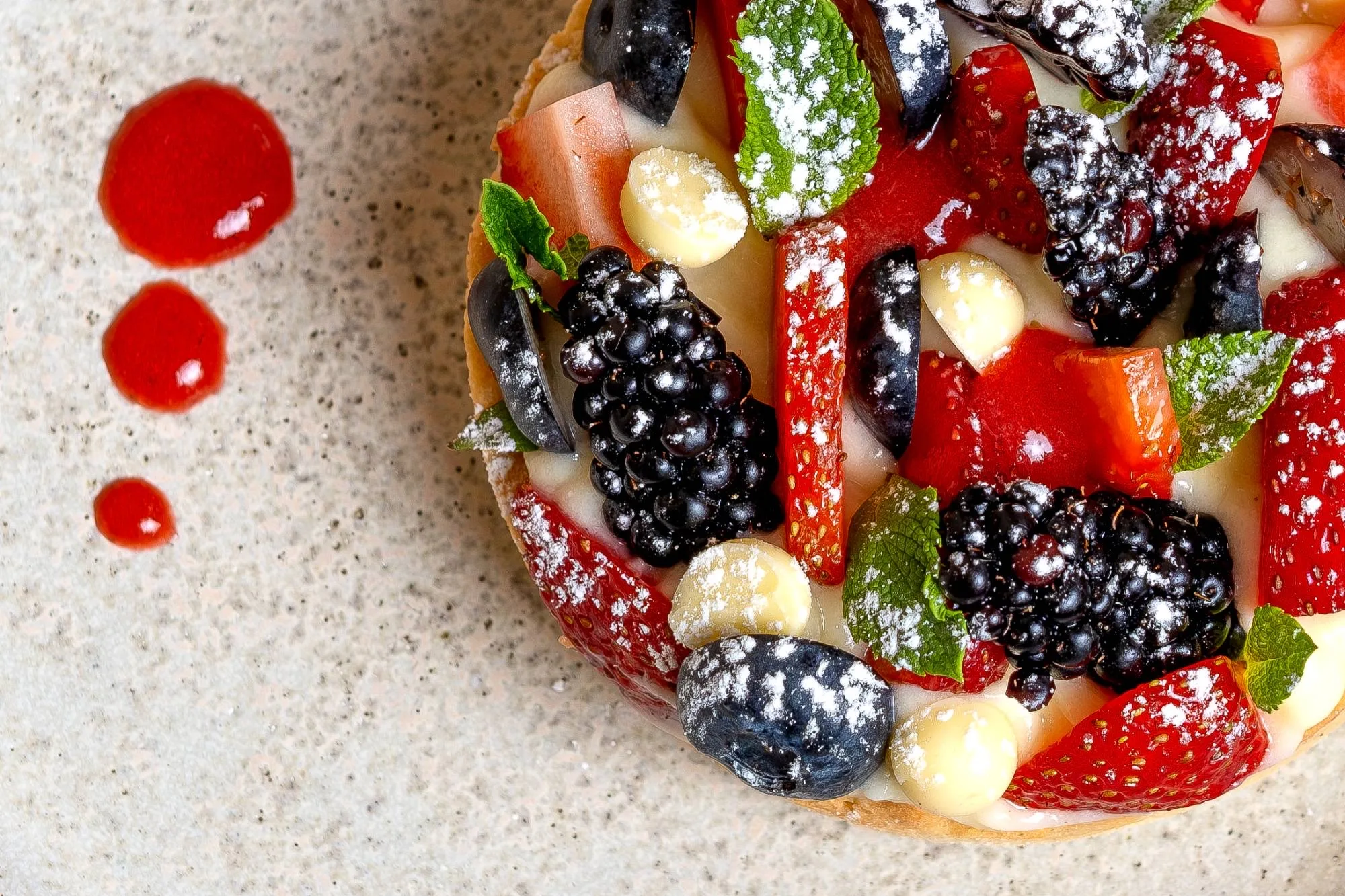 Detalle de la tartaleta: fresas, moras, chocolate blanco y coulis de fresa